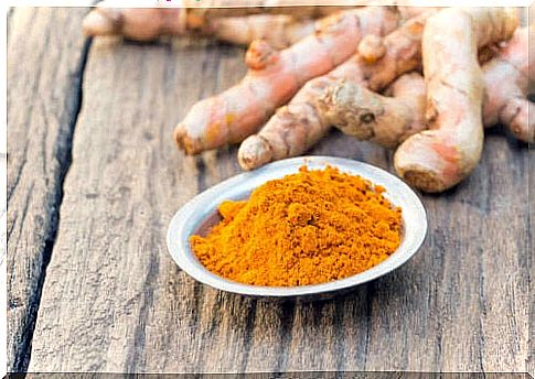 Painted turmeric on a wooden table with turmeric root behind