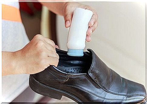 Woman putting talcum powder in a shoe