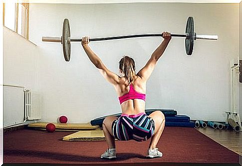 Woman doing sumo squat with barbell