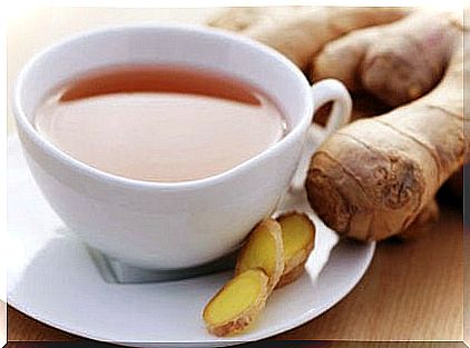 A cup of ginger with fresh ginger on the table next to it - herbal remedies for cough