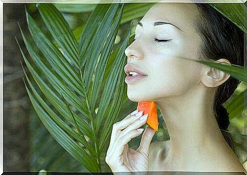 Woman smearing papaya on her neck