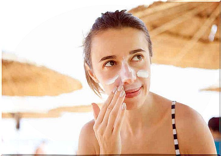 A woman smearing sunscreen on her face