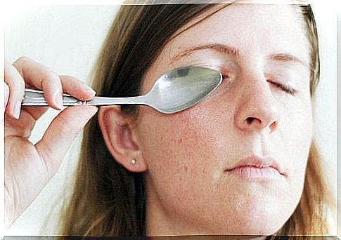 Woman with spoon in front of eye