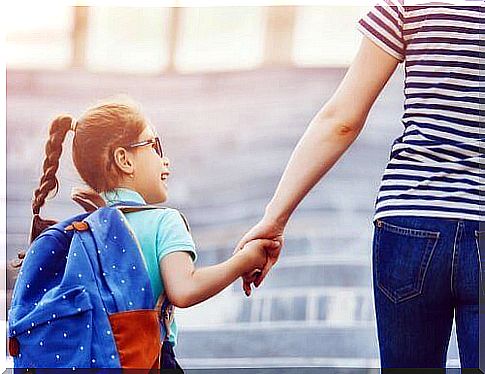 Mother with daughter with school bag on