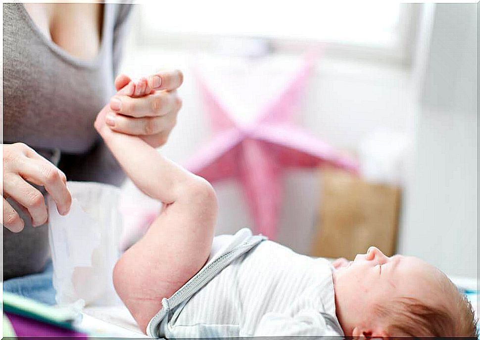 Mother changes her baby's diaper