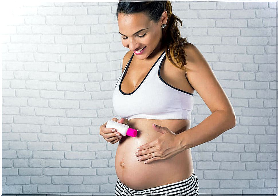 Woman lubricates her pregnant belly