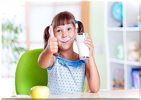 Girl with milk beard and a glass of milk in hand